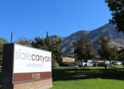Thumbnail 13 of 13 - a sign for store canyon apartments with mountains in the background