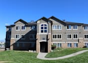 Thumbnail 15 of 16 - a large apartment building with a sidewalk in front of it