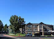 Thumbnail 16 of 16 - a large apartment building with cars parked in front of it