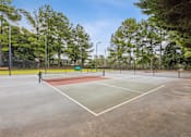 Thumbnail 13 of 17 - a tennis court with a red and green court in a park