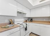 Thumbnail 4 of 23 - a white kitchen with white appliances and white cabinets
