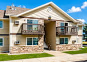 Thumbnail 3 of 5 - A two-story residential building with a balcony on the second floor.
