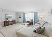 Thumbnail 2 of 23 - a living room with a couch and a chair and a tv
