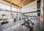 Thumbnail 8 of 24 - Fitness with cardio equipment and vaulted ceiling at Lofts at Innovation Center Apartments, Richland, 99354
