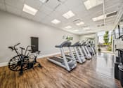 Thumbnail 7 of 24 - Fitness with cardio equipment and wood flooring at Lofts at Innovation Center Apartments, Richland