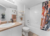 Thumbnail 9 of 23 - a bathroom with a shower and a sink and a toilet