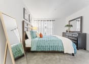 Thumbnail 7 of 23 - a bedroom with a bed and a mirror
