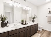 Thumbnail 11 of 17 - A bathroom with a white countertop and a white toilet.