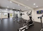 Thumbnail 5 of 14 - A gym with a row of treadmills and elliptical machines.