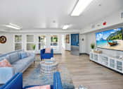 Thumbnail 1 of 8 - A living room with a grey sofa and a blue armchair.