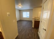 Thumbnail 3 of 31 - an empty living room and kitchen with wood flooring