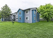 Thumbnail 1 of 11 - A blue and grey two story apartment building with a mailbox in front.