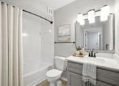 Thumbnail 30 of 31 - A bathroom with a white toilet, sink, and a shower with a white tub at Waterbridge Apartments , Orlando