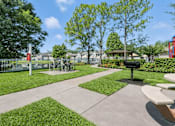Thumbnail 6 of 31 - A park with a bench, a fence, and a tree. at Waterbridge Apartments , Florida
