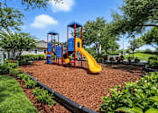 Thumbnail 8 of 31 - A playground with a yellow slide and a blue and red structure. at Waterbridge Apartments , Orlando, Florida