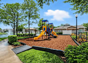 Thumbnail 7 of 31 - A playground with a yellow slide and a blue swing set. at Waterbridge Apartments , Orlando, 32837