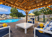 Thumbnail 1 of 31 - A patio with a table and chairs under a roof with lights. at Waterbridge Apartments , Florida, 32837