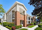 Thumbnail 2 of 28 - A modern two-story apartment building with a brick pillar and number 333 on it.
