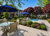 Thumbnail 4 of 28 - A patio with a table and chairs and umbrellas.