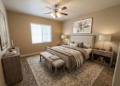 Thumbnail 17 of 17 - A bedroom with a large bed, a ceiling fan, and a rug on the floor.