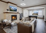 Thumbnail 4 of 17 - A living room with a fireplace and a large screen TV mounted on the wall.