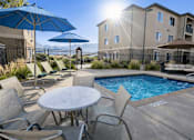 Thumbnail 7 of 17 - A sunny day at the poolside with chairs and umbrellas.