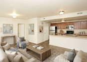 Thumbnail 14 of 17 - A modern living room with a white couch and a coffee table.