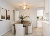 Thumbnail 22 of 30 - A dining room with a table and chairs.