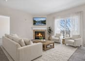 Thumbnail 12 of 21 - Living room with fireplace and large windows at Stetson Meadows Apartments, Colorado Springs, CO