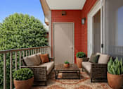 Thumbnail 21 of 21 - Covered balcony with wicker seating and potted plants at Stetson Meadows Apartments, Colorado