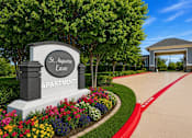 Thumbnail 1 of 21 - A sign for St. Augustine Estate Apartments is surrounded by flowers.