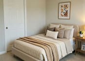 Thumbnail 8 of 10 - A bedroom with a bed, a ceiling fan, and a nightstand with a plant on it.