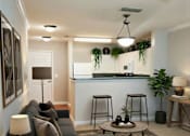 Thumbnail 5 of 10 - A living room with a grey sofa, a wooden side table, and a rug.
