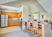 Thumbnail 6 of 20 - A kitchen with wooden cabinets and a stainless steel refrigerator.