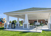 Thumbnail 15 of 20 - A white pavilion with a green roof is surrounded by a grassy area.