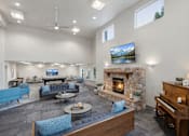 Thumbnail 5 of 24 - A living room with a fireplace and a television mounted on the wall.
