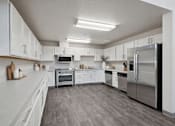 Thumbnail 6 of 24 - A modern kitchen with stainless steel appliances and white cabinets.