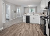 Thumbnail 11 of 18 - Open kitchen with white cabinetry and black appliances at Davidson Homes Apartments, Concord