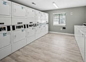 Thumbnail 6 of 18 - Community laundry facility with stacked washers and dryers at Davidson Homes Apartments, Concord, NC 28027