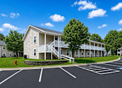 Thumbnail 2 of 20 - A large building with a parking lot in front of it.