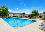 Thumbnail 5 of 20 - A swimming pool with a metal ladder and a blue umbrella.