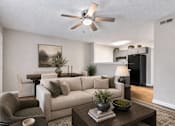 Thumbnail 13 of 20 - A living room with a couch, chair, and a ceiling fan.