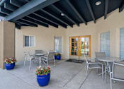Thumbnail 7 of 16 - Covered patio with outdoor dining furniture at Vista Linda Apartments, New Mexico