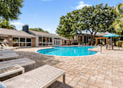 Thumbnail 2 of 28 - A pool area with sun loungers and a building in the background. at Epic Apartments , Daytona Beach, 32114