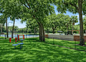 Thumbnail 9 of 28 - A park with a blue bench and a red object. at Epic Apartments , Daytona Beach