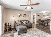 Thumbnail 24 of 28 - A living room with a grey couch and a wooden coffee table. at Epic Apartments , Florida