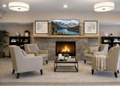 Thumbnail 22 of 37 - Resident lounge with fireplace and seating at The Estates at Arbor Oaks Apartments, Andover, MN