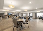 Thumbnail 27 of 37 - Spacious dining room with fireplace and seating at The Estates at Arbor Oaks Apartments, Andover, 55304