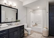 Thumbnail 24 of 24 - A bathroom with a black cabinet and a white toilet.