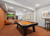 Thumbnail 12 of 24 - A room with a pool table and a fireplace.